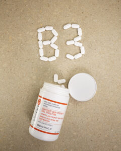 Niacinamide tablets, open bottle with tablets spelling out b3